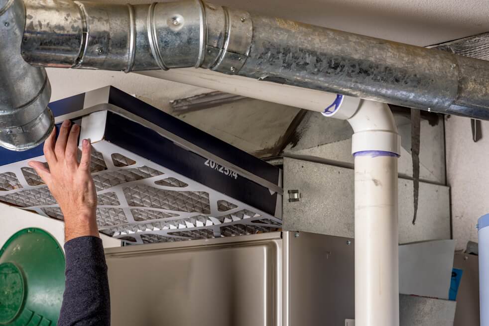 man changing furnace filter