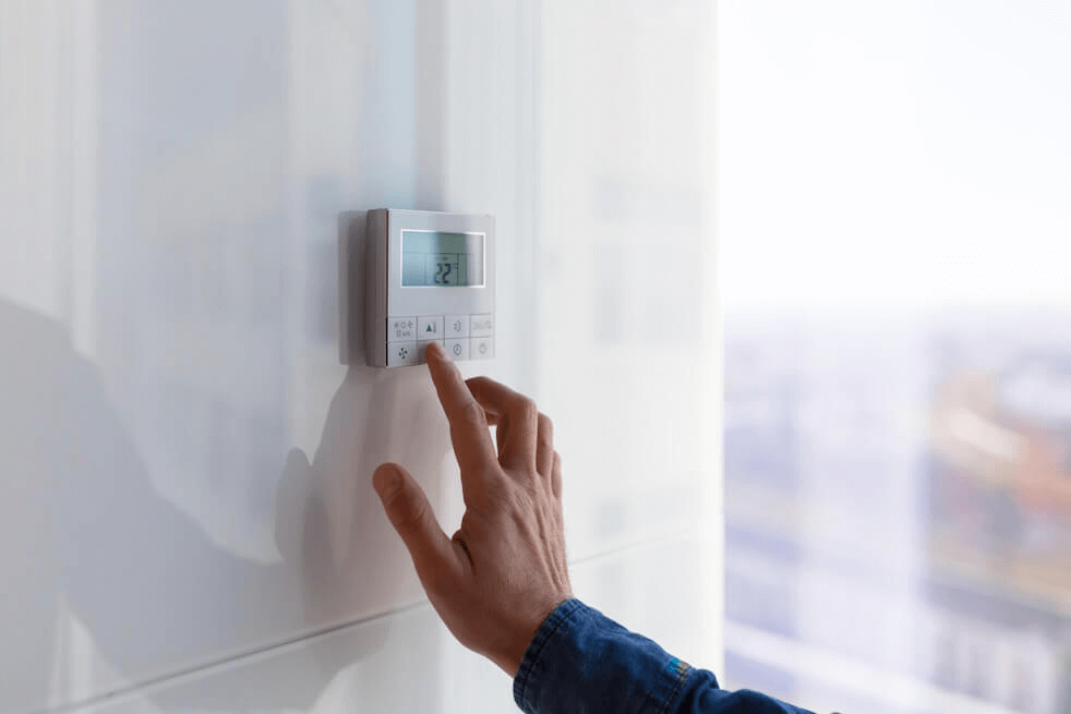 homeowner adjusting thermostat