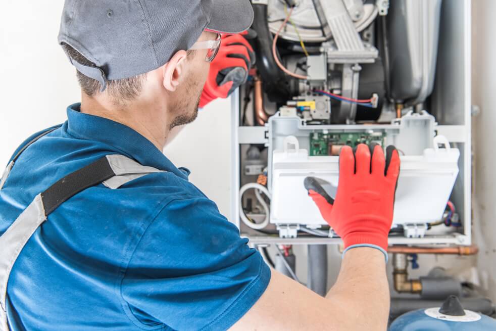 hvac technician repairing furnace